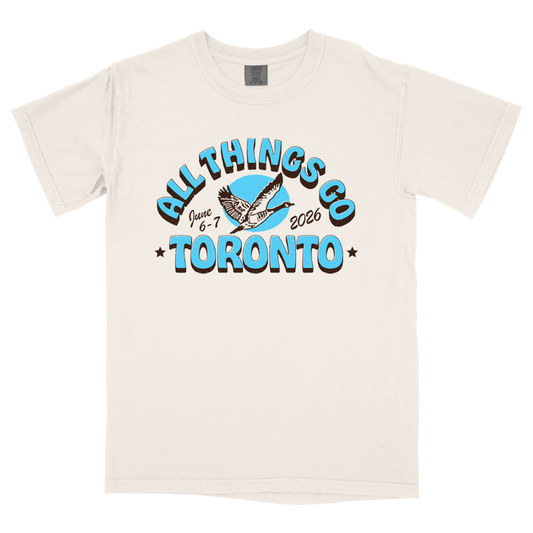 Beige t-shirt with 'All Things Co Toronto' graphic design on a white background